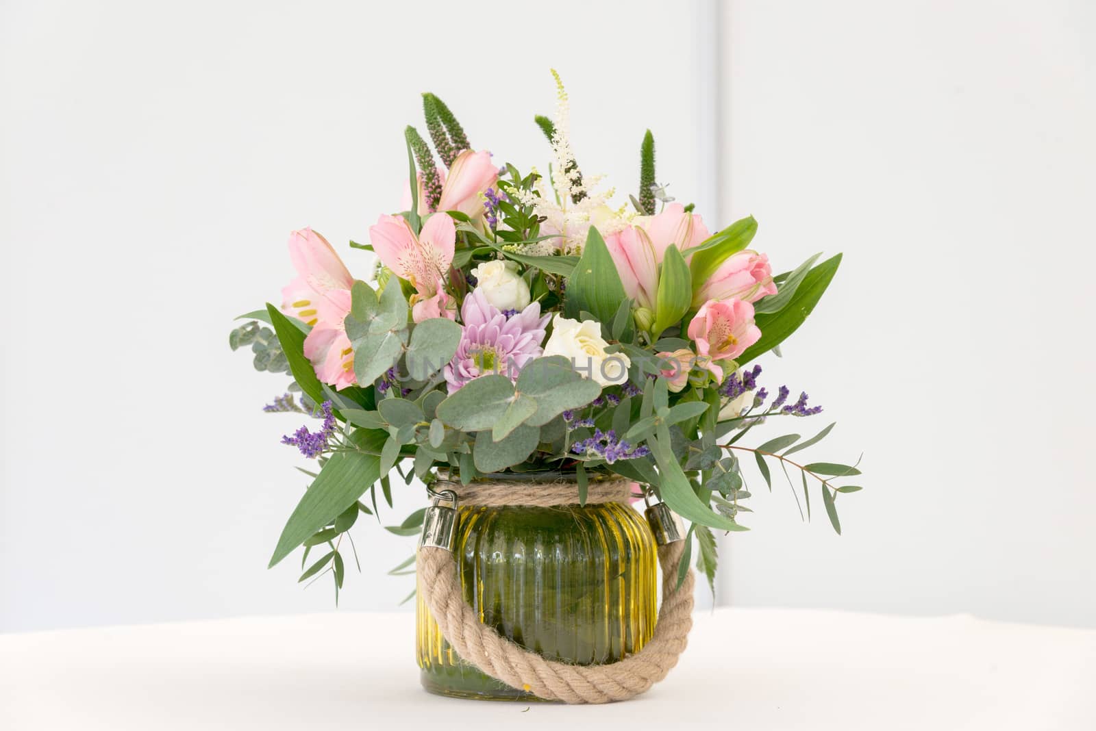 beautiful flower arrangement on white festive table by vlaru