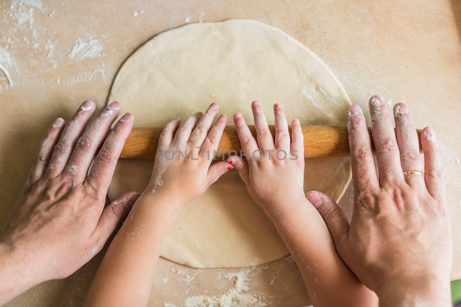 Children and dad hands rolled dough by okskukuruza