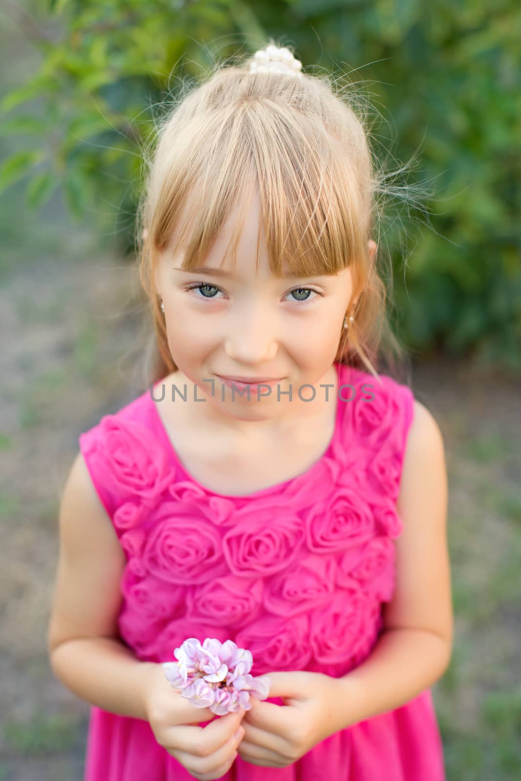 Portrait of the girl in the green bushes, close-up