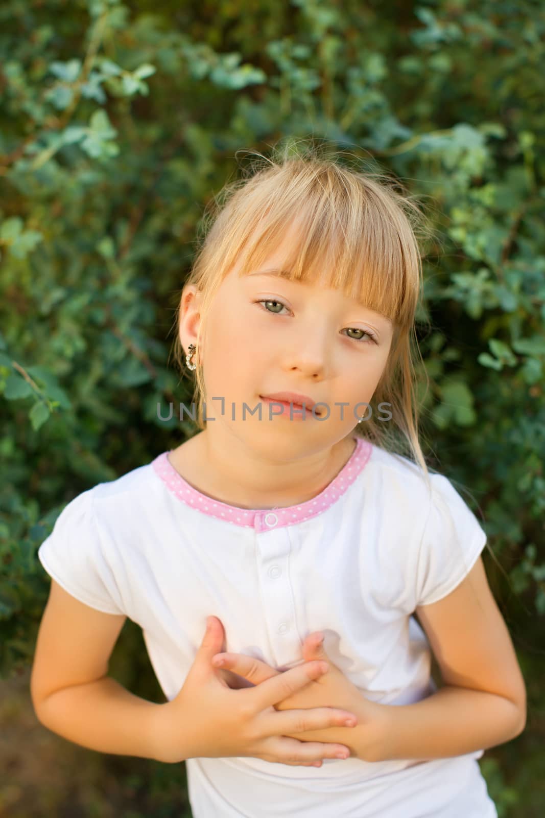 Portrait of the girl in the green bushes, close-up