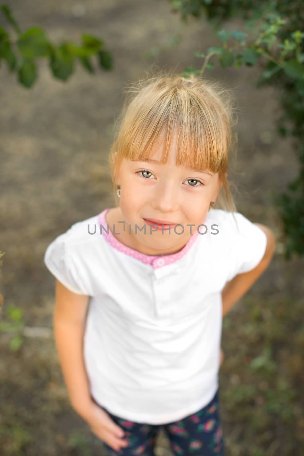 Portrait of the girl in the green bushes, close-up