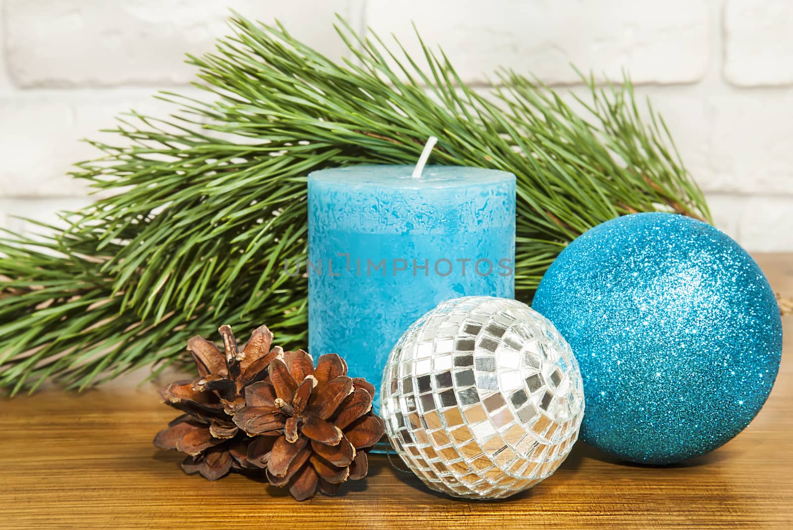 New Year 2017 composition with bright blue glitter ball and candle on wooden back ground
