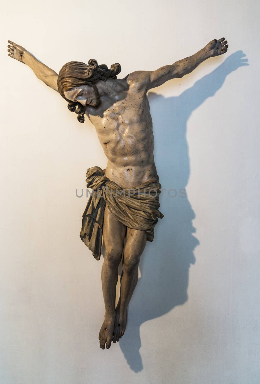 Crucifix of Jesus on the cross with stone background. Symbol of christian religion and belief.