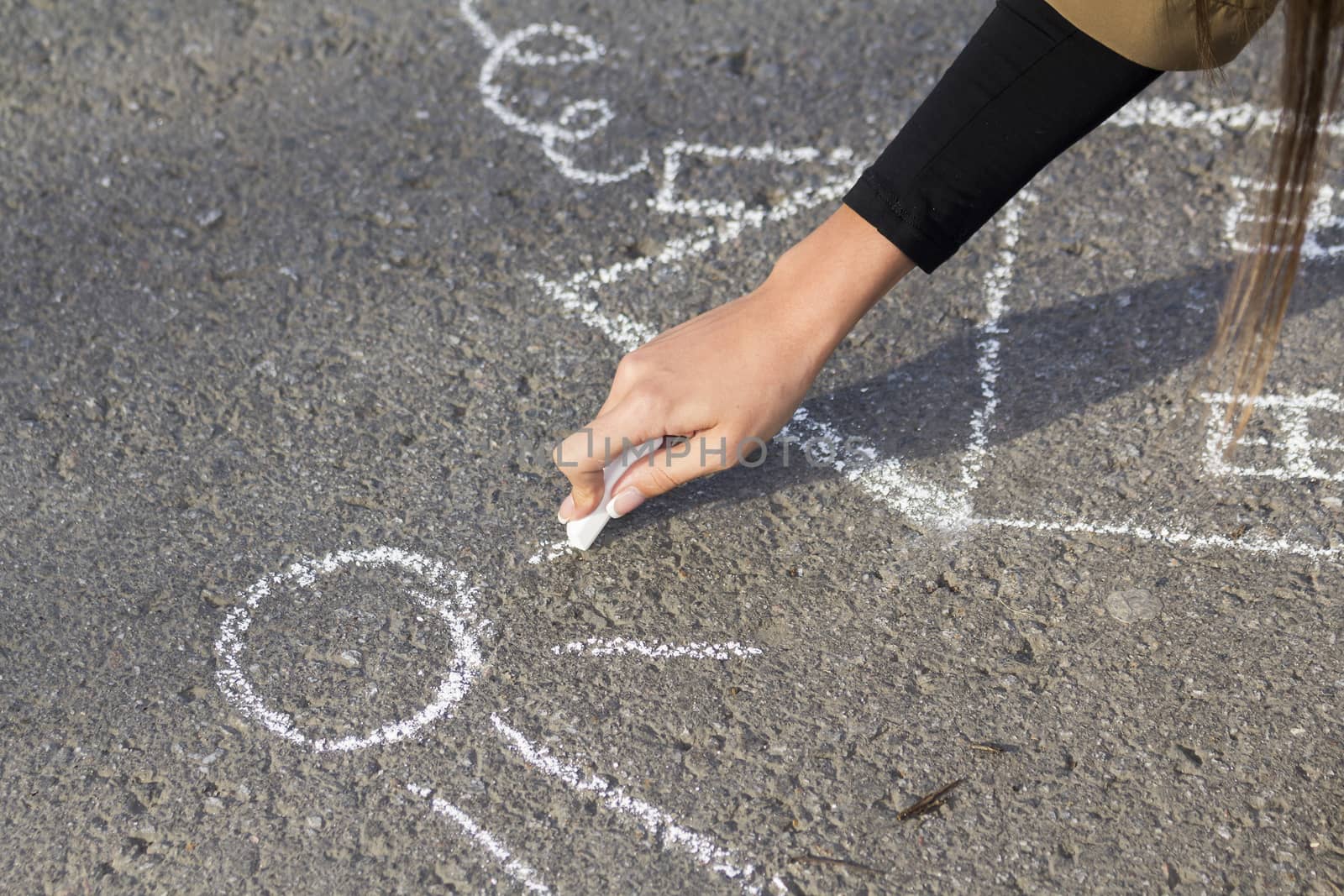 Arm girls with chalk draws home and Sun on the sidewalk