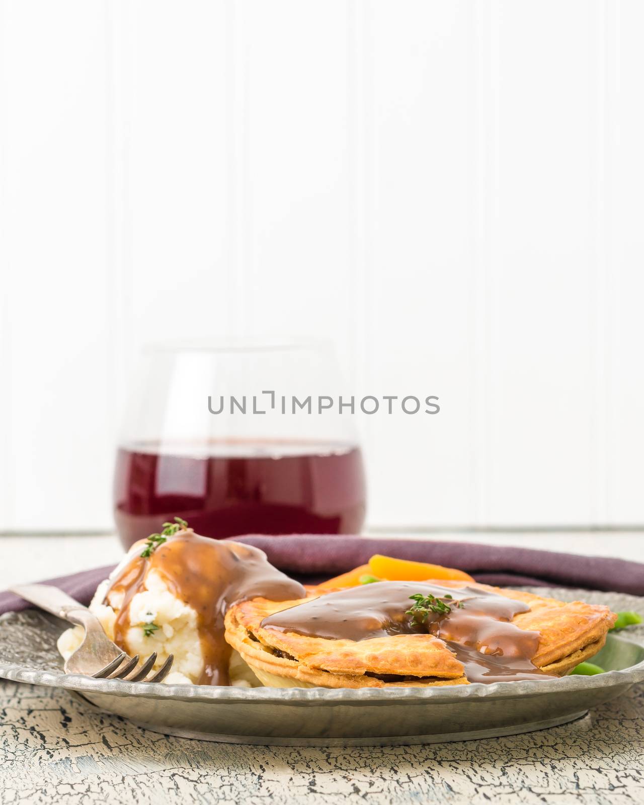 Beef and mushroom meat pie served with mashed potatoes and fresh vegetables.