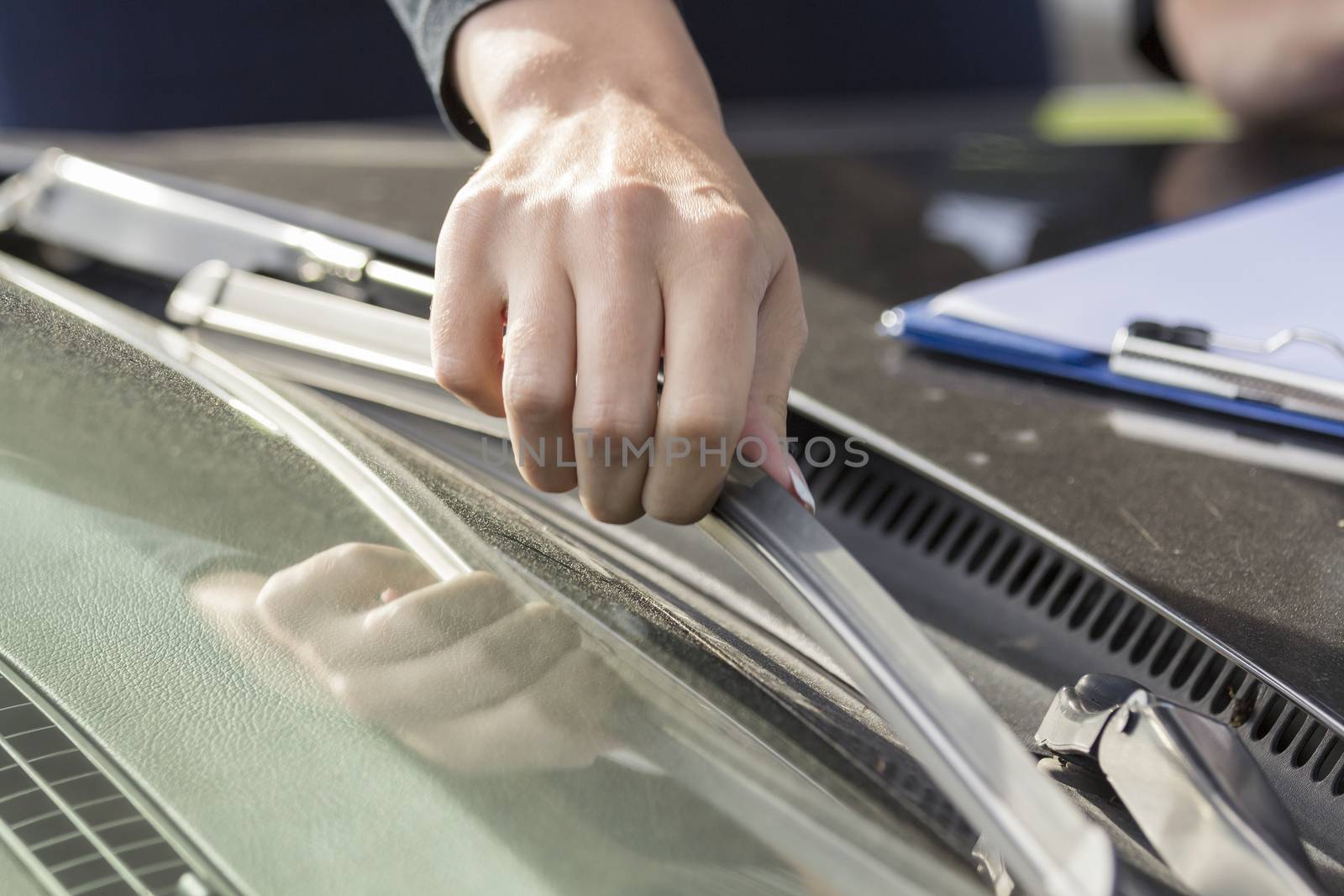 The wipers on the glass car regulates the hand of the girl