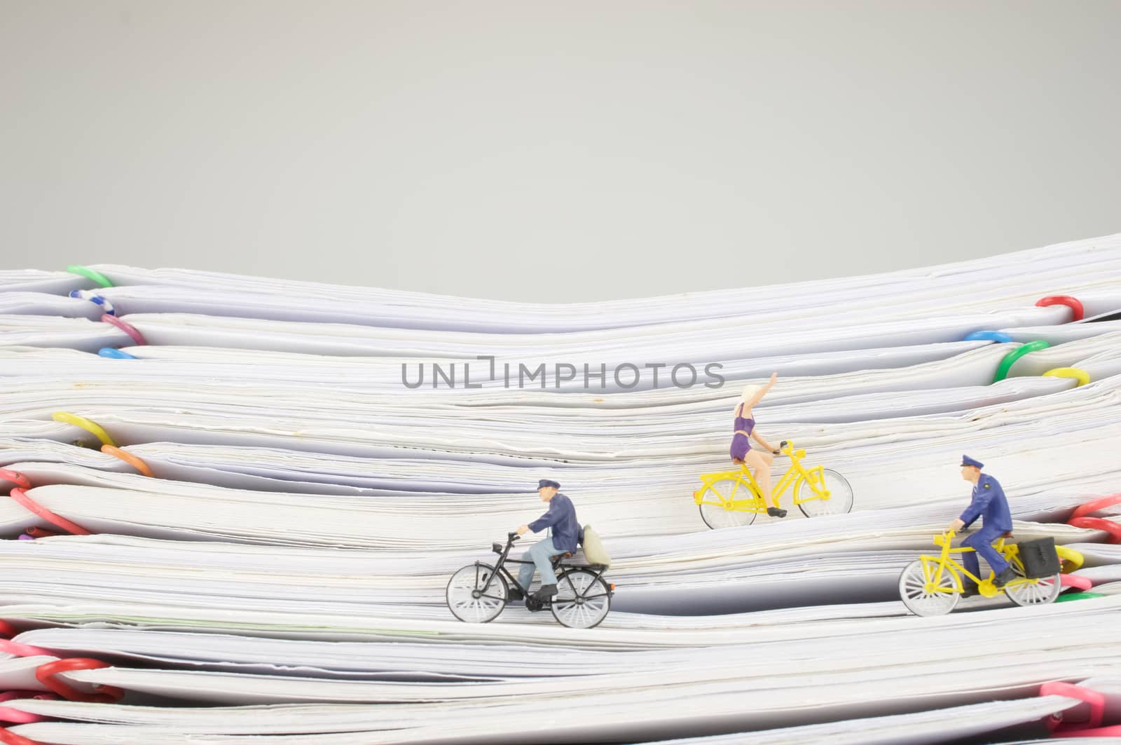 Postmen and woman is cycling on pile overload paperwork of report and receipt with colorful paperclip with white background.