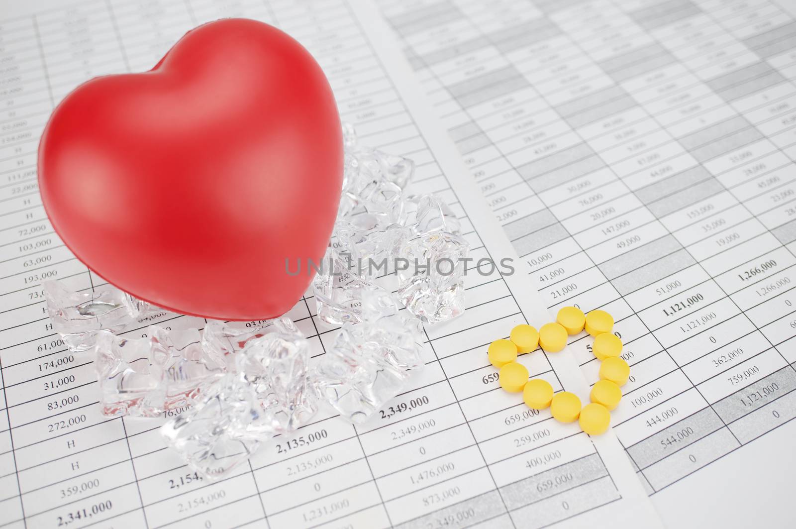 Yellow pills place as heart shape on finance report by eaglesky