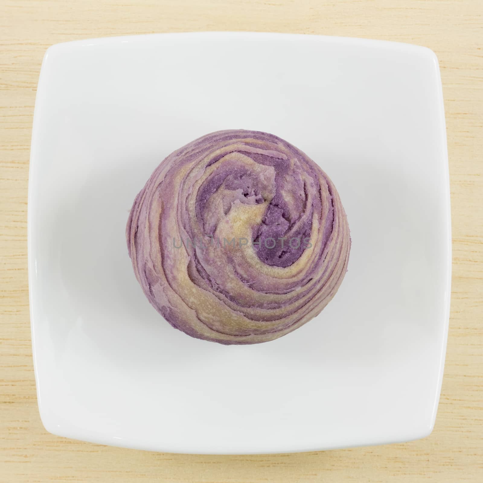 The Taiwanese violet crystal taro cake on the small white square dish.