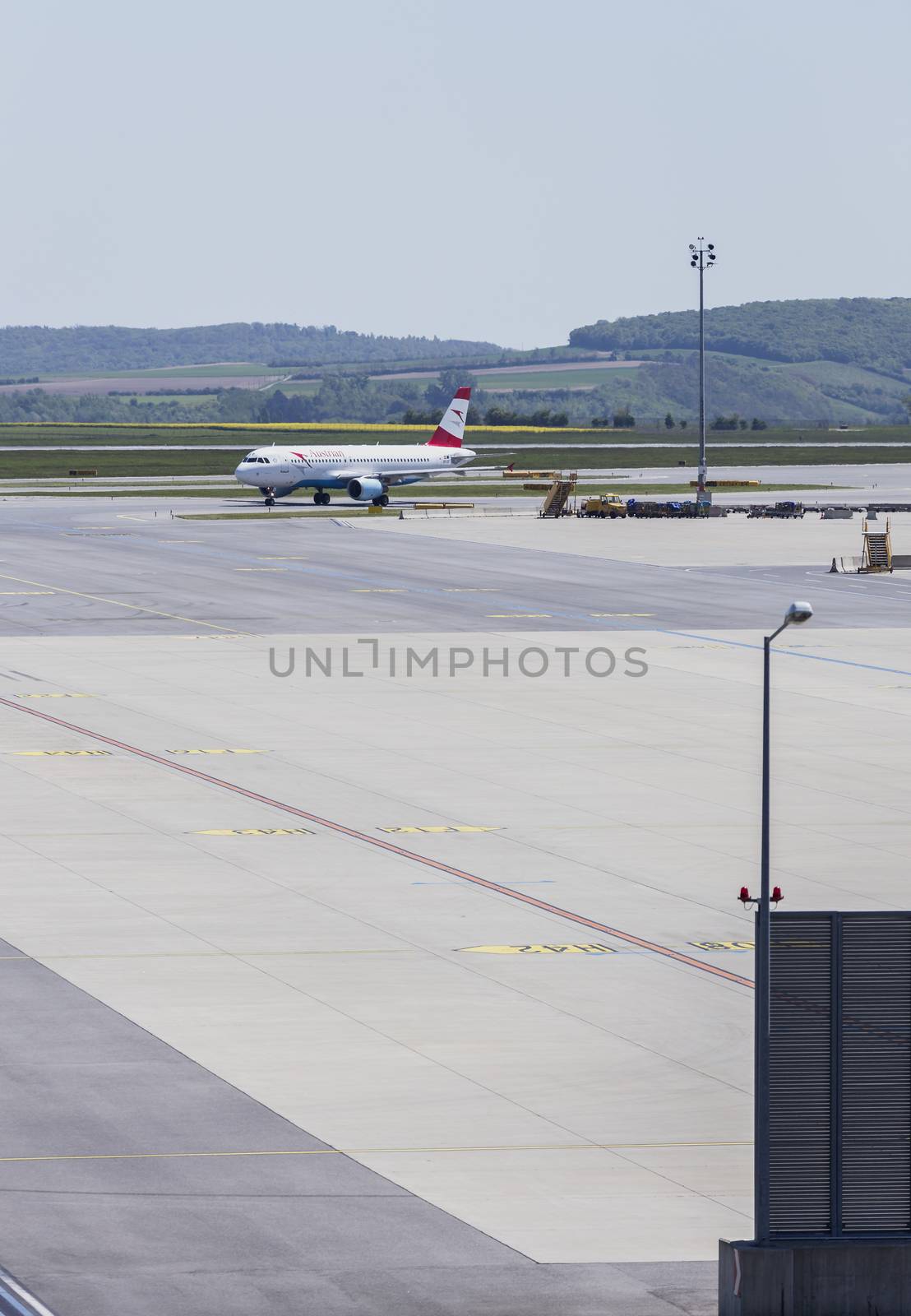 VIENNA, AUSTRIA – APRIL 30th 2016: Plane arriving to terminal area at Vienna International Airport on a busy Saturday.