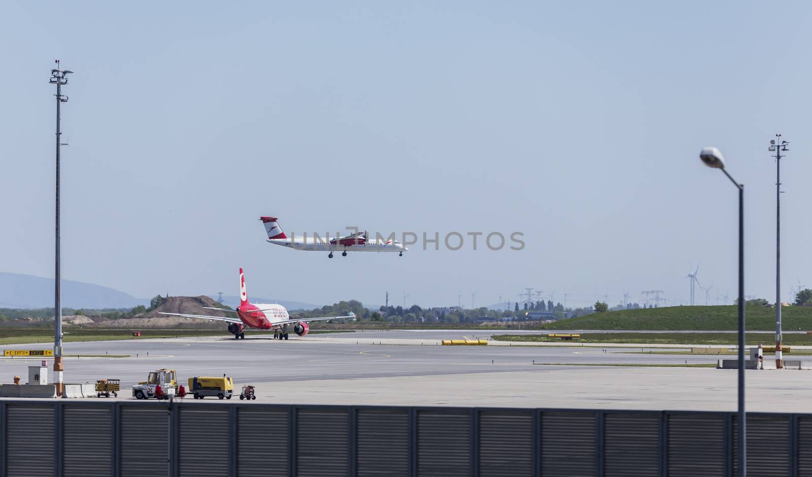 VIENNA, AUSTRIA – APRIL 30th 2016: Plane landing on a busy Saturday at Vienna International Airport.