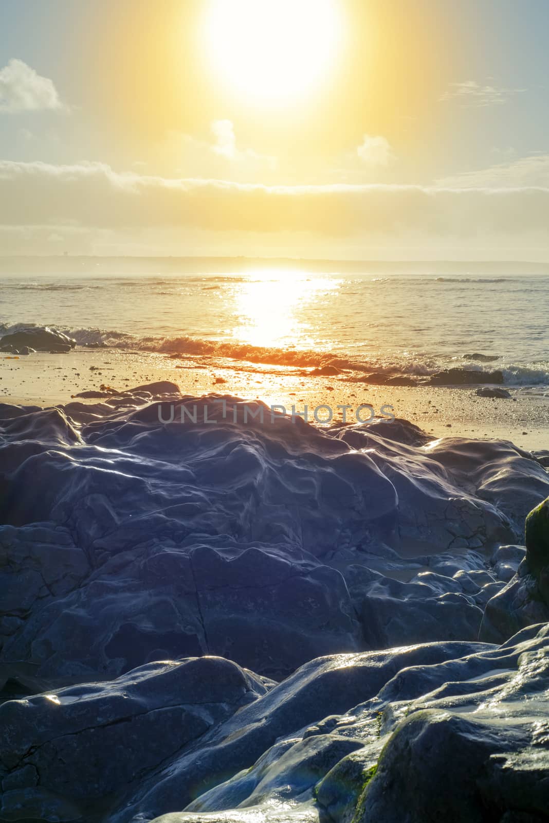 beautiful soft waves break on the rocks on sunset ballybunion beach in ireland