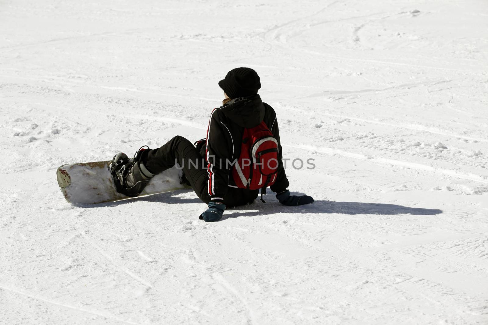 Snowboarder siting on fresh powder snow