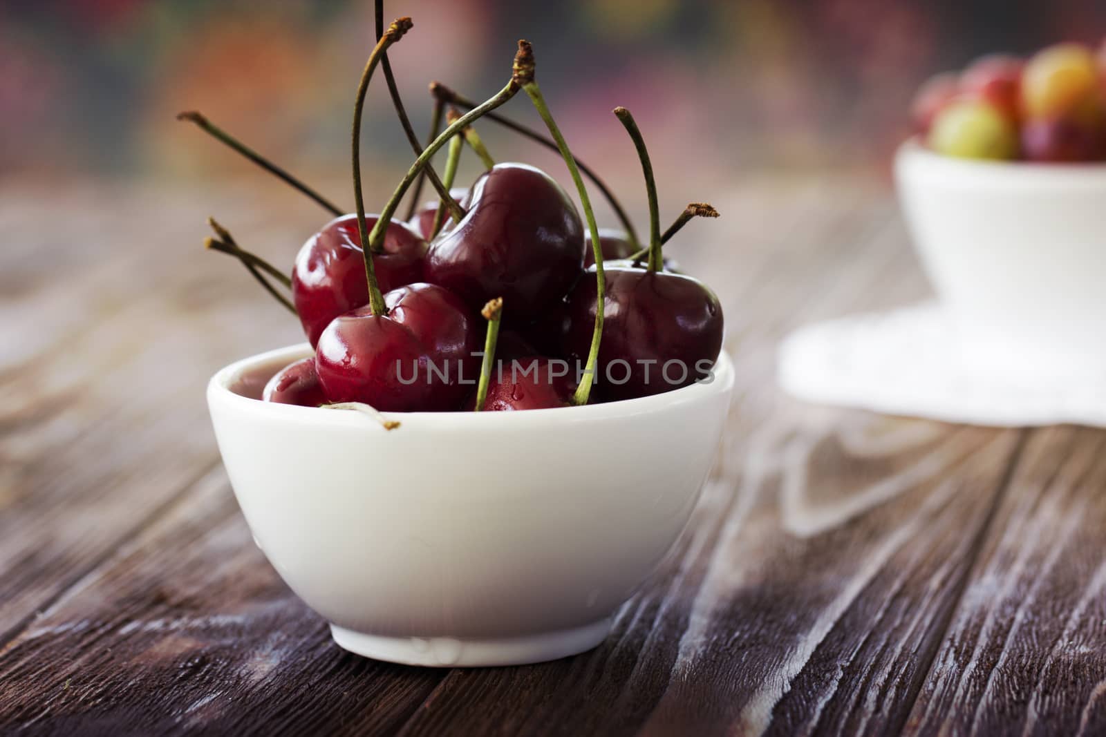 Fresh cherries in bowl on table