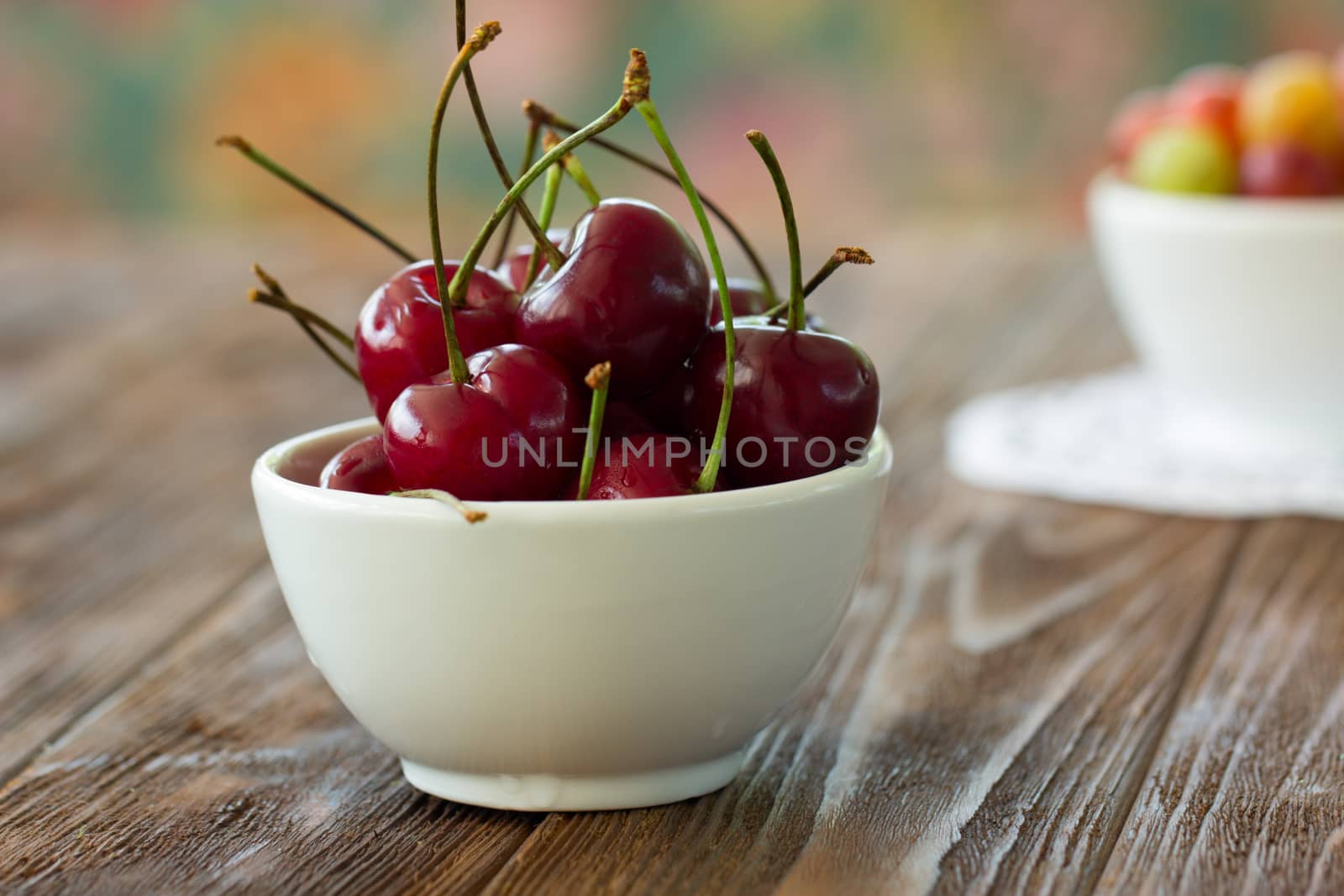 Fresh cherries in bowl on table