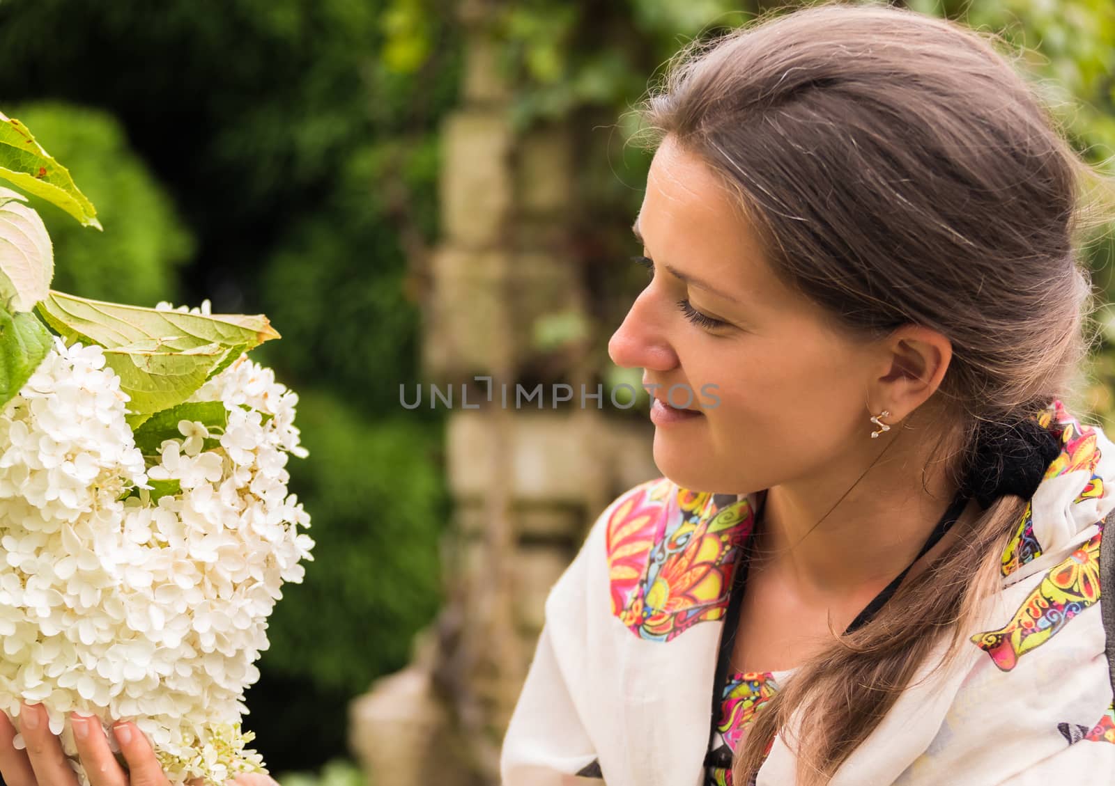 portrait of a woman holding hydrangea flower in hand