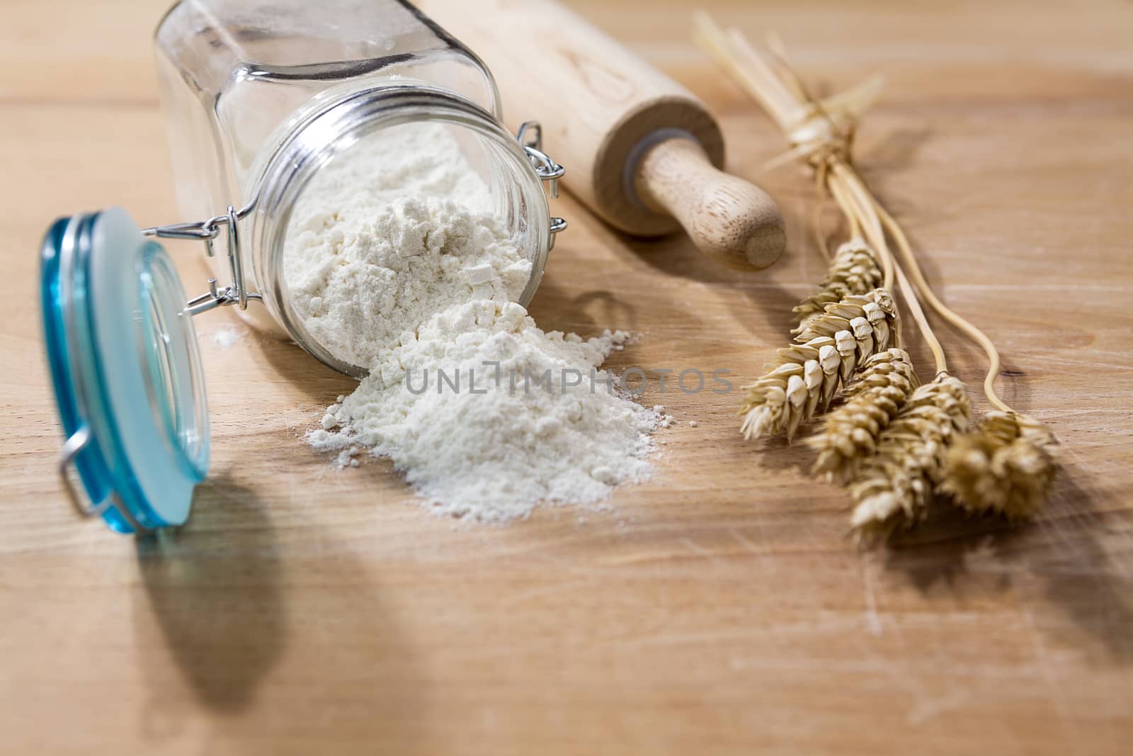 Flour in glass jar with rolling pin and sheaves of wheat by LuigiMorbidelli