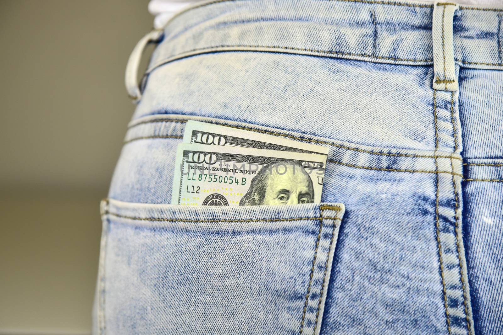 Money sticking out of a blue  jean pocket.