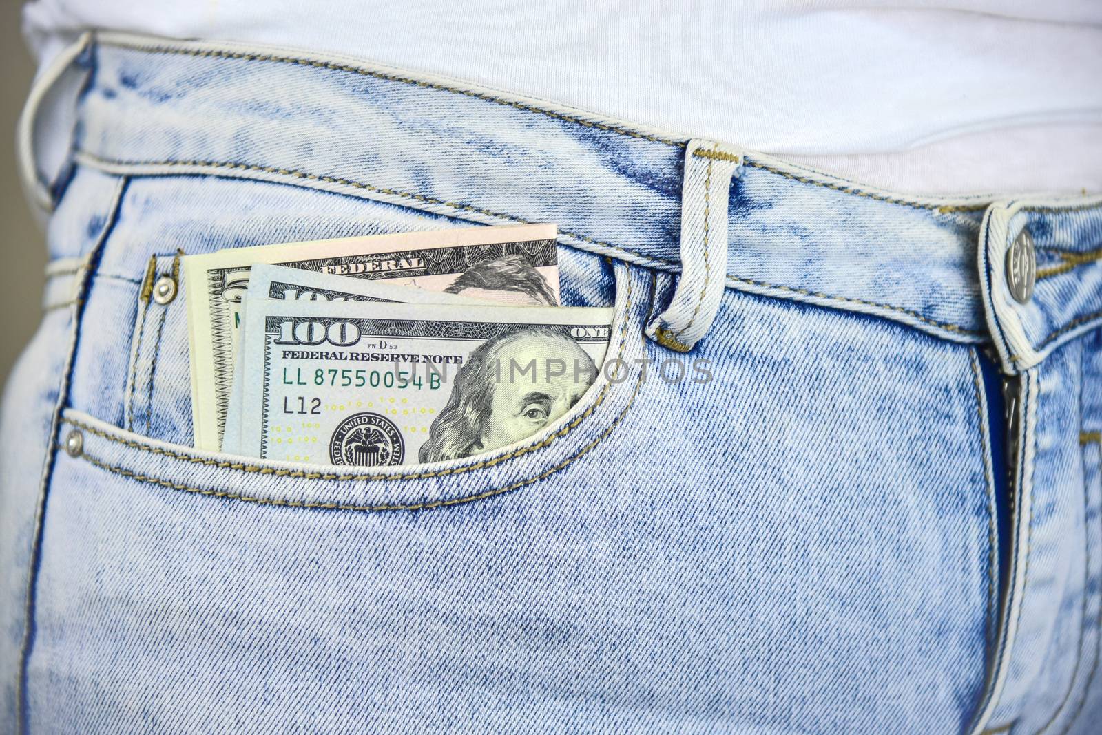 Money sticking out of a blue  jean pocket.