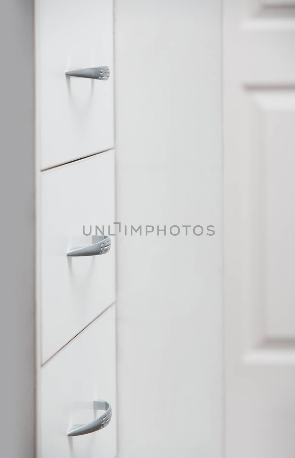 Cabinet with sliding trays and chrome handles. Vertical photo
