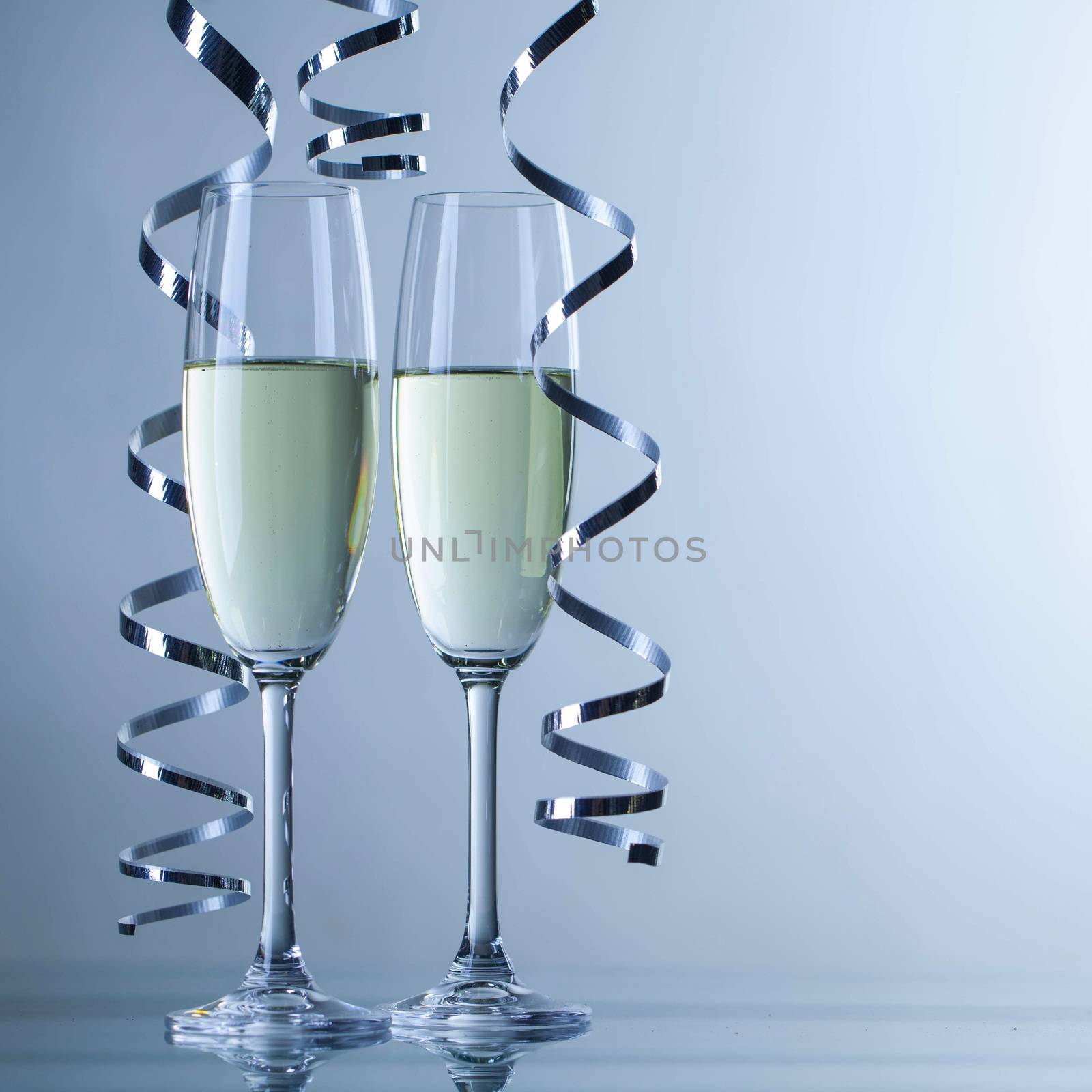 Two champagne glasses and curly ribbon party concept