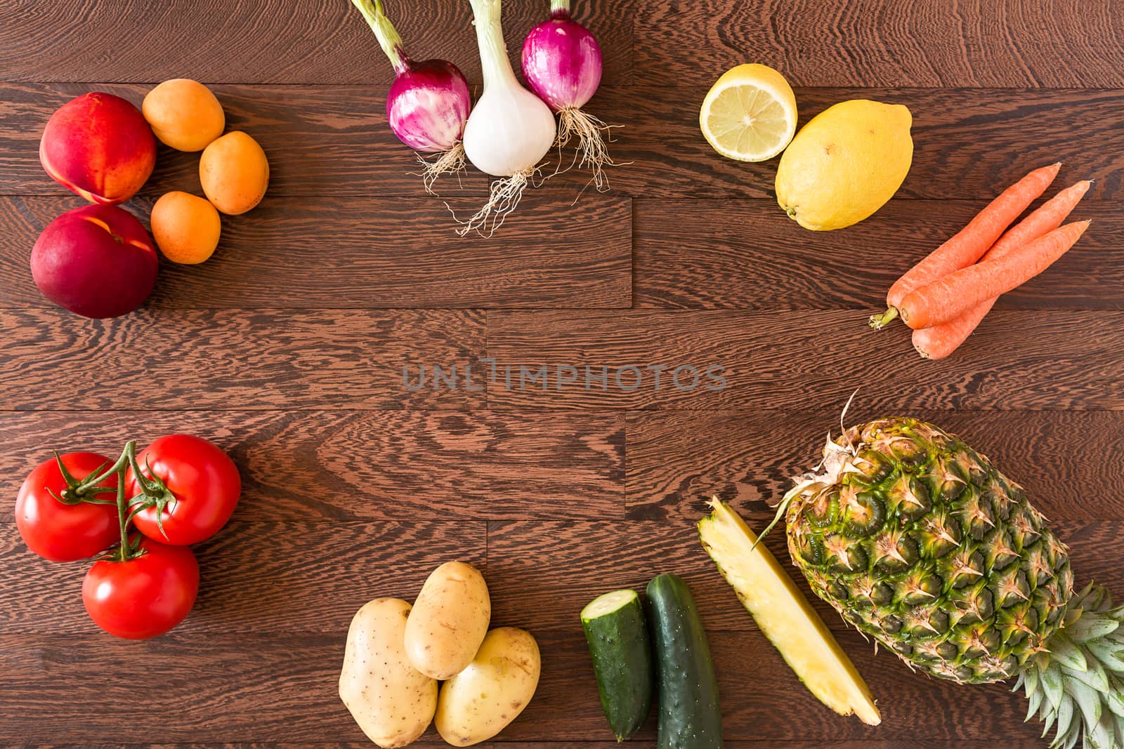 Different raw vegetables and fruits over a wooden background