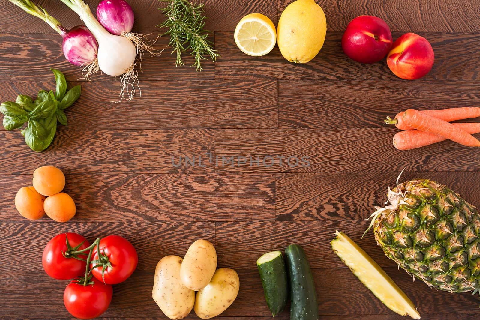 Assorted raw vegetables and fruits over a wooden background