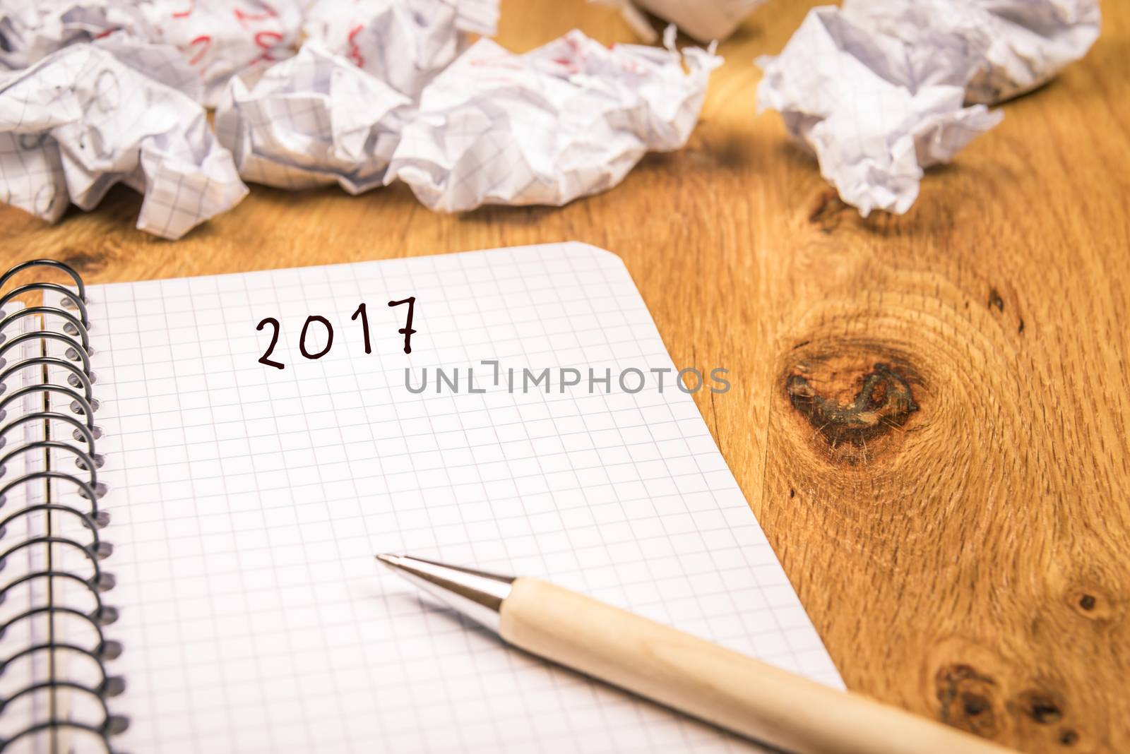 New year concept with 2017 written on a graph, spiral notebook and crumpled pages in the background suggesting the passing of years.