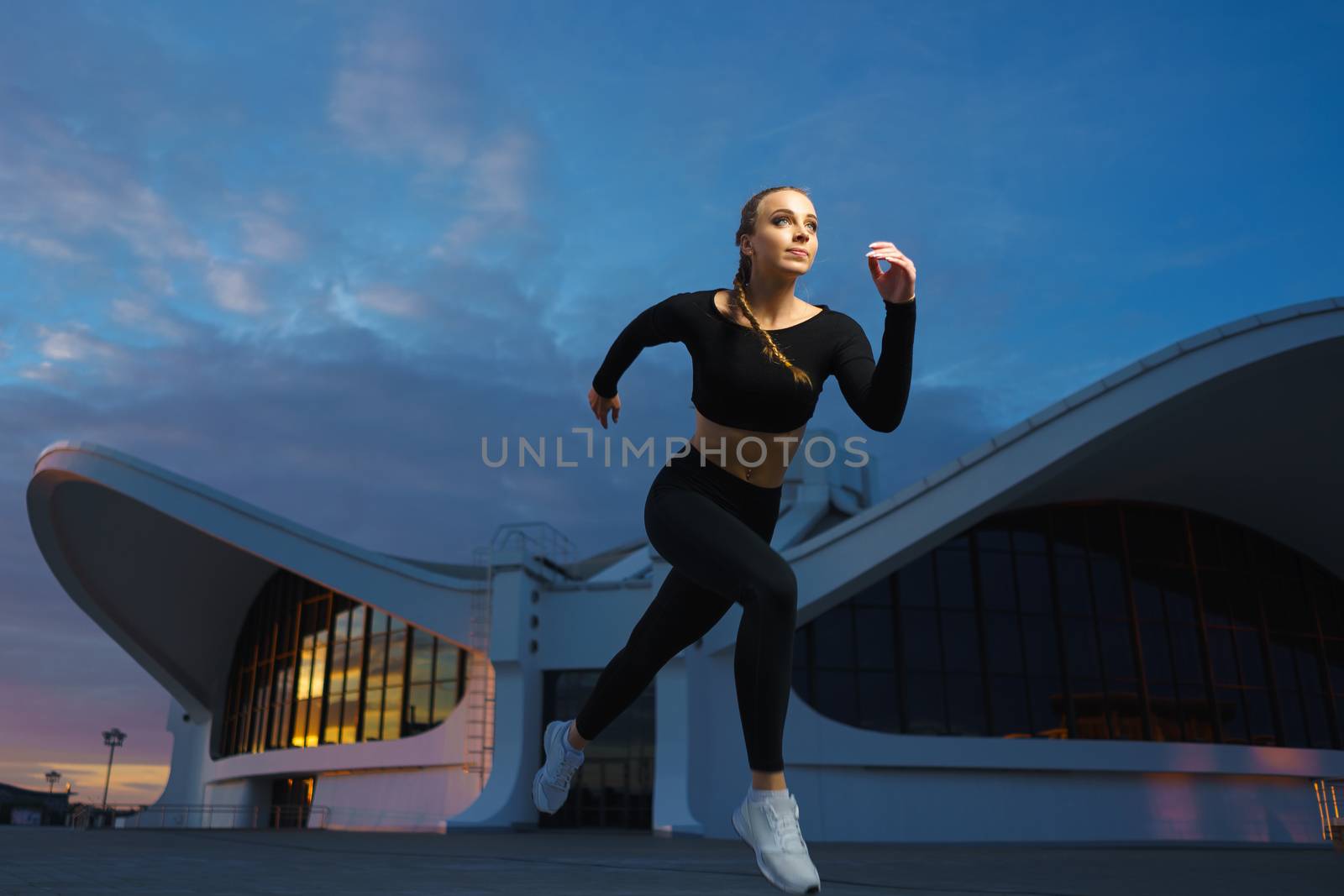 Happy girl run outdoor at modern urban area during sunset. by mrakor