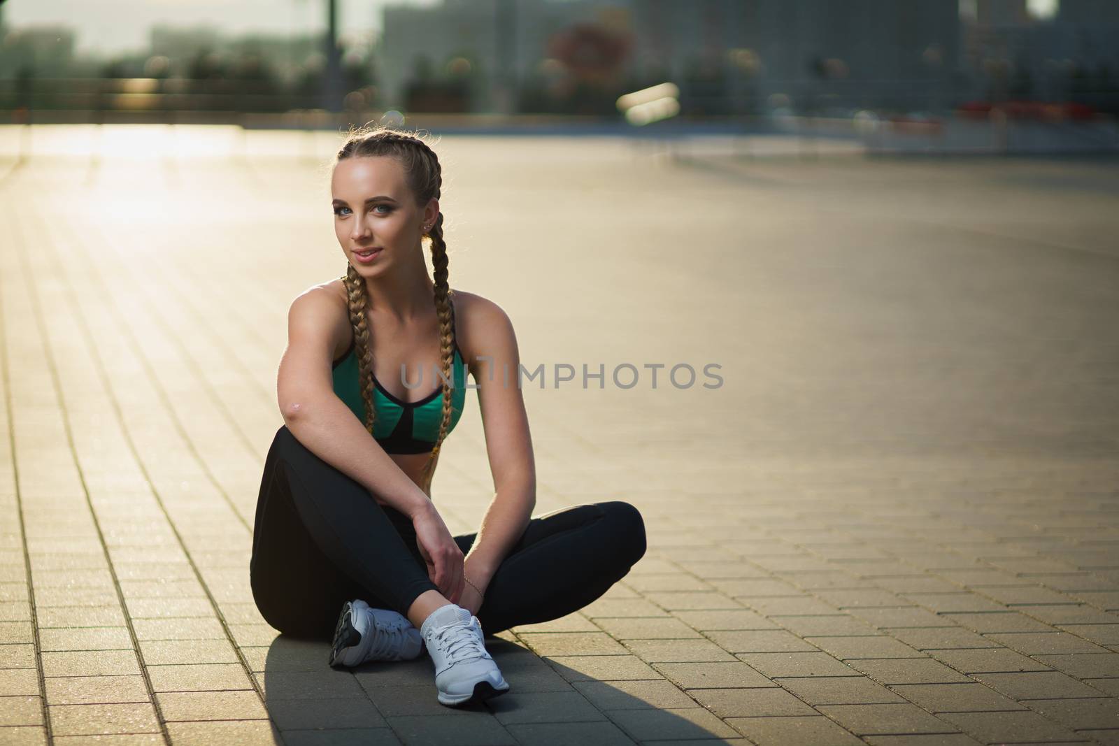 Concept: healthy lifestyle, sport. Attractive happy girl fitness trainer do outdoor workout at modern downtown urban area during sunset.