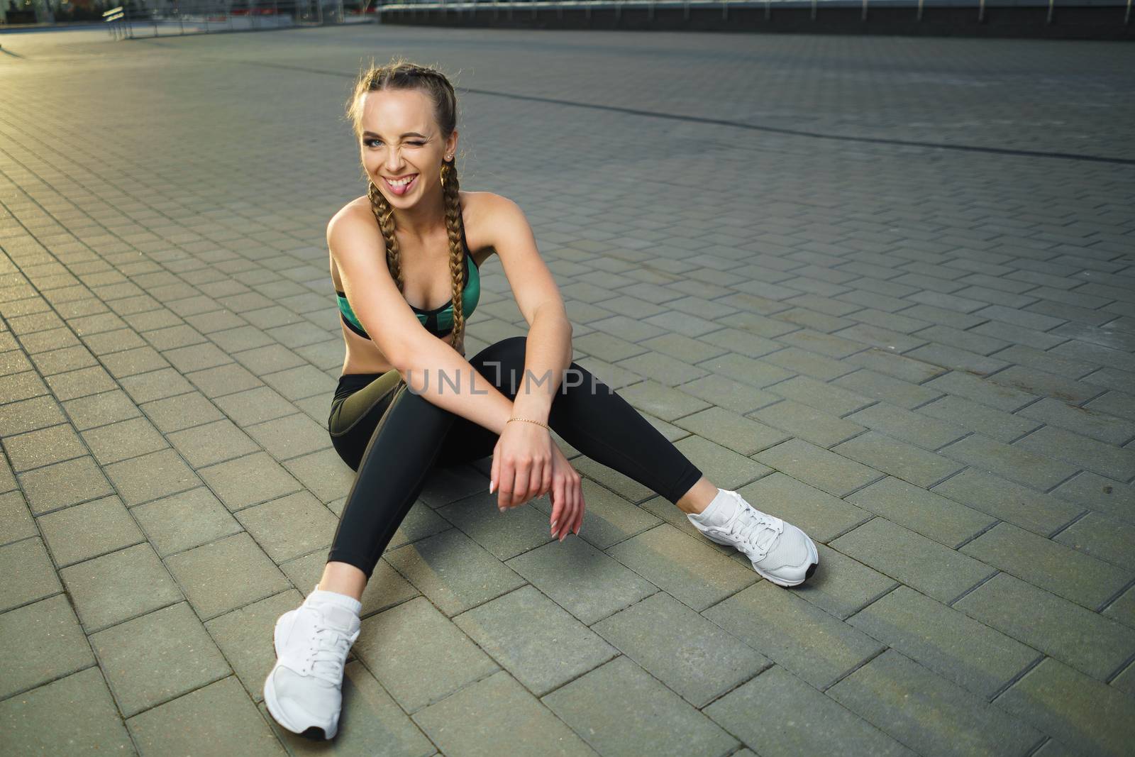 Concept: healthy lifestyle, sport. Attractive happy girl fitness trainer do outdoor workout at modern downtown urban area during sunset.