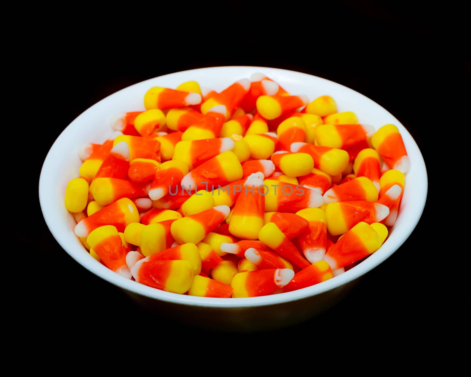 Candy Corn in a bowl isolated against a black background