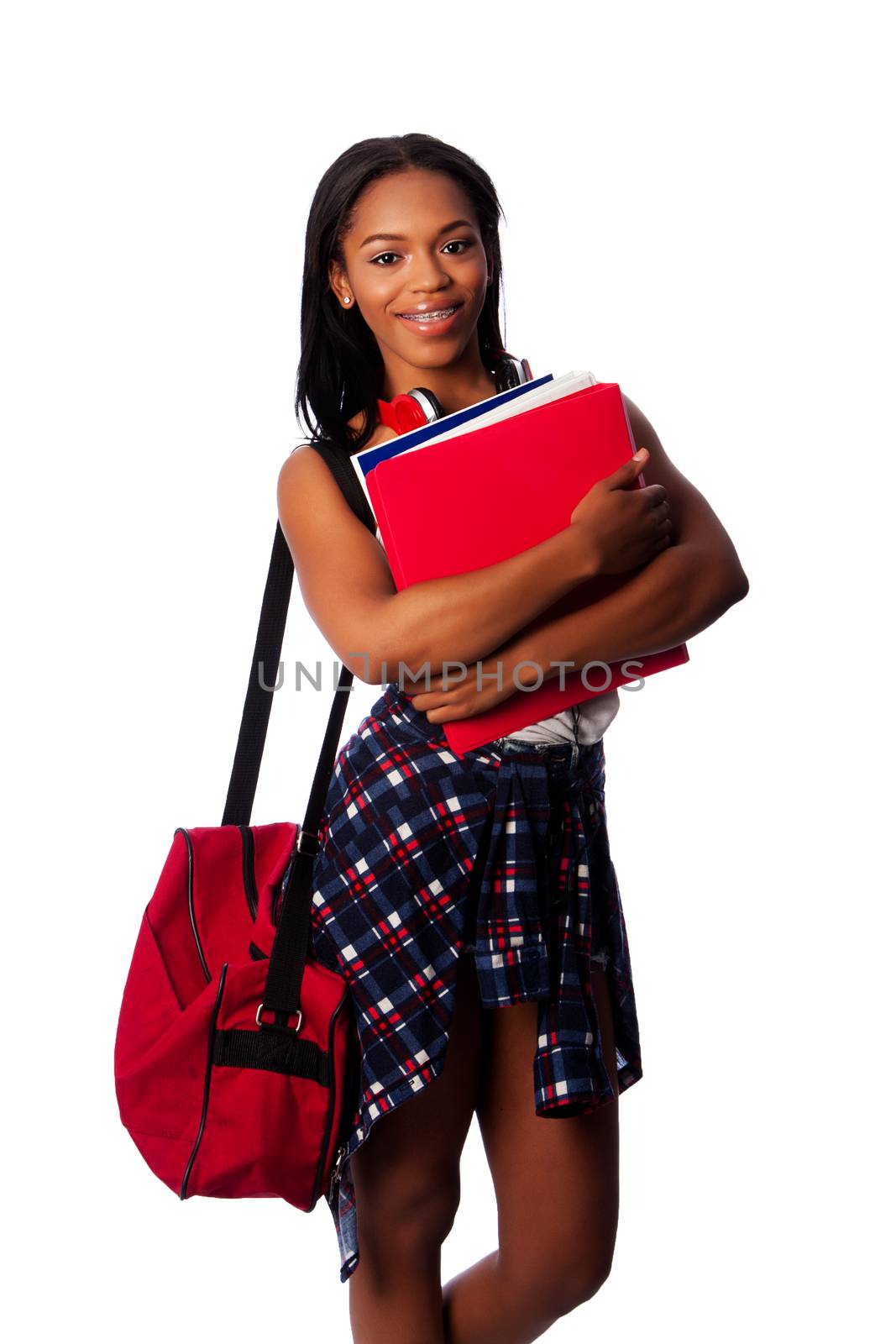 Beautiful happy student standing with binders, books, notepads and bag, on white.