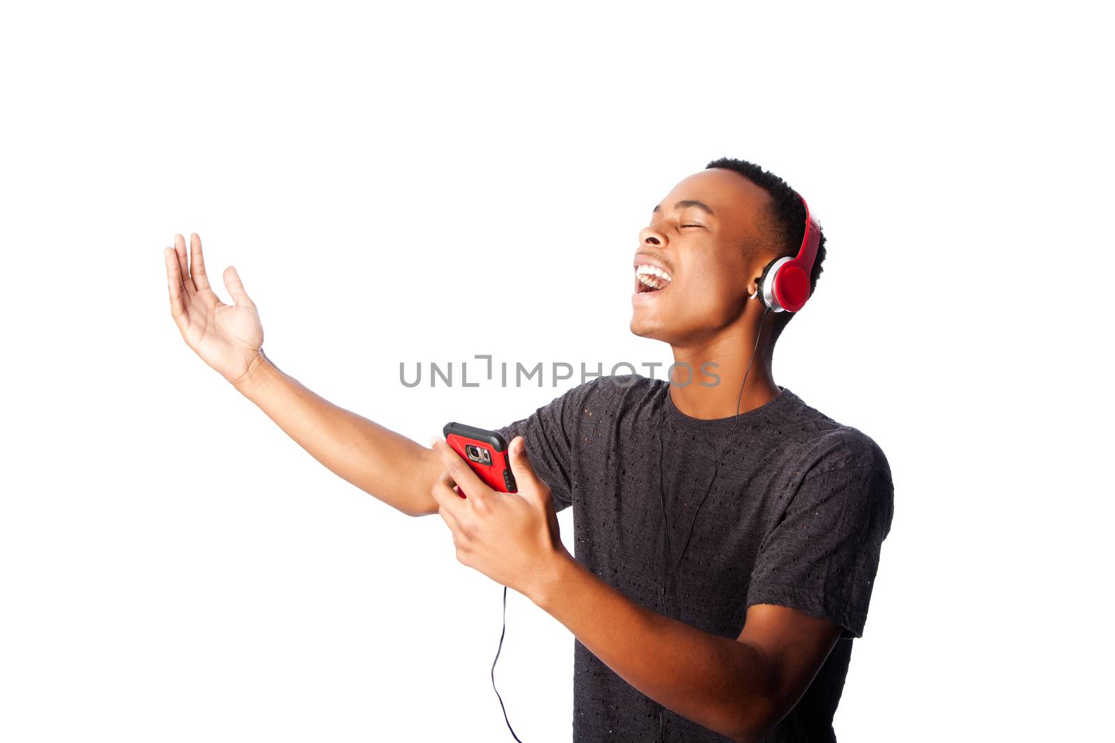 Handsome African teenager happily singing along while listening to music, on white.