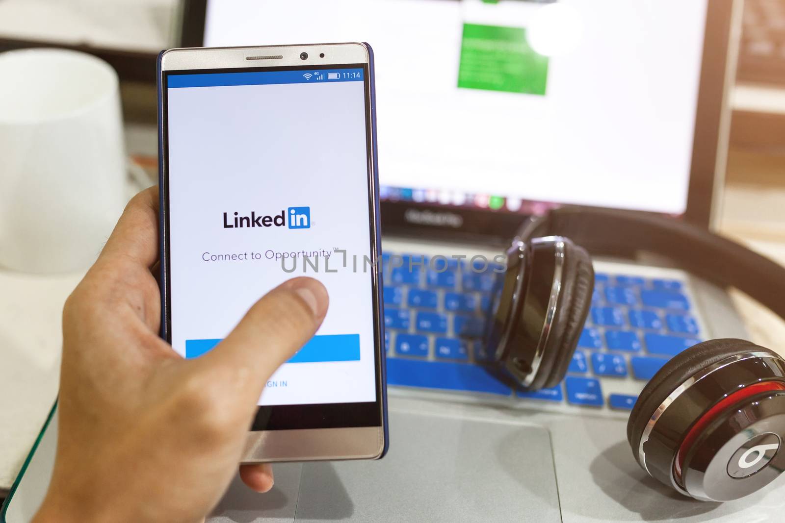 Man hand holding android device with LinkedIn on the screen by nopparats