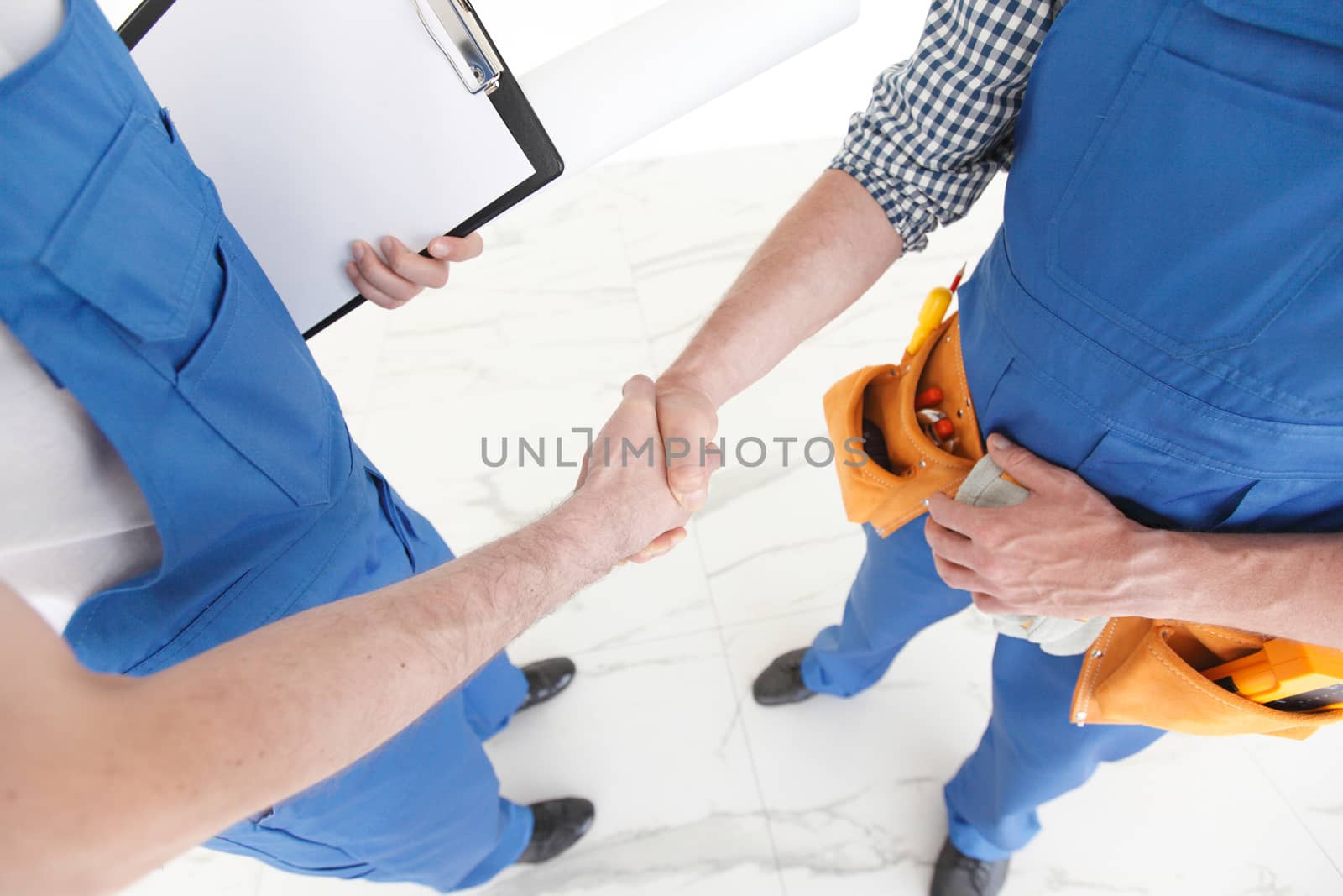 Construction workers shaking hand by ALotOfPeople