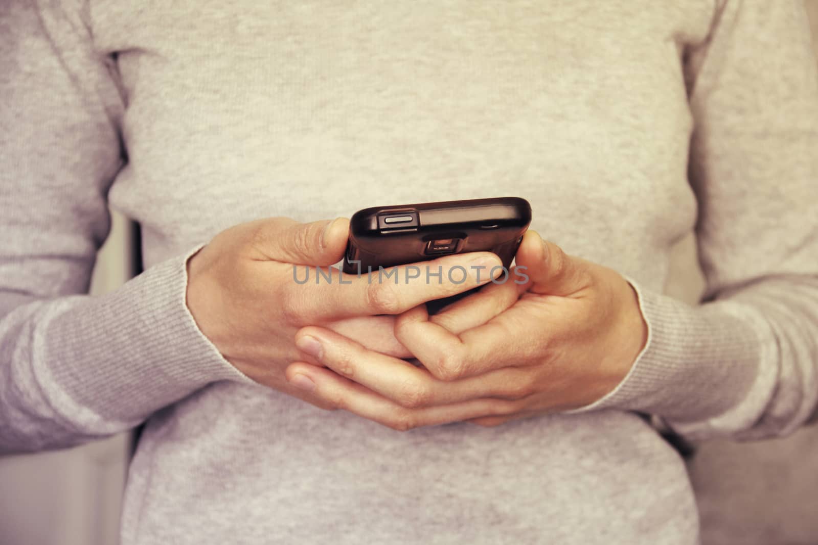 Hands holding smartphone toned in vintage style