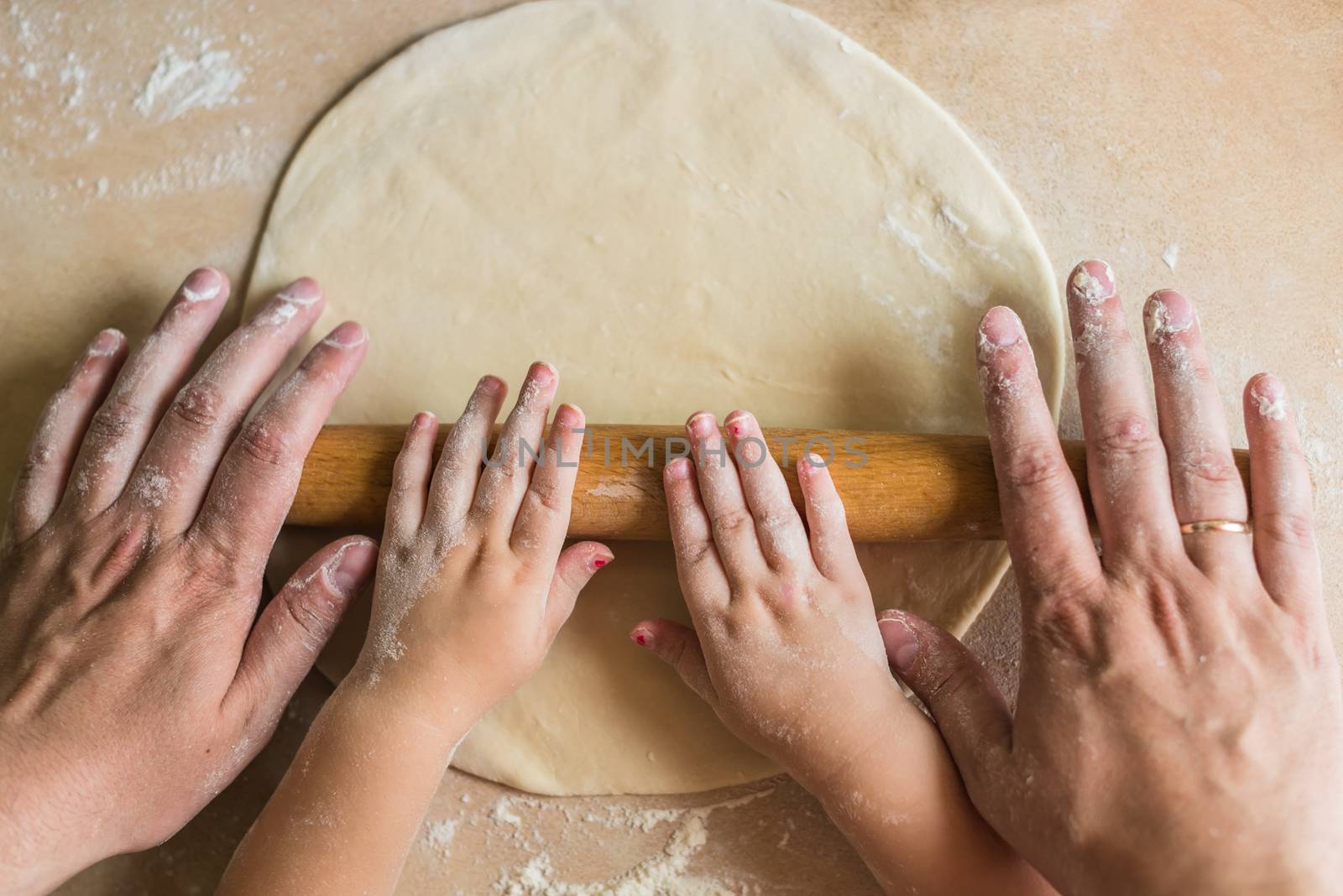 Children and dad hands rolled dough by okskukuruza