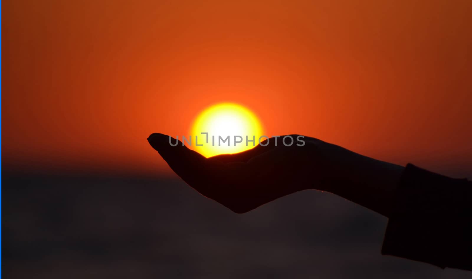 Close up of woman hand holding sun in hand