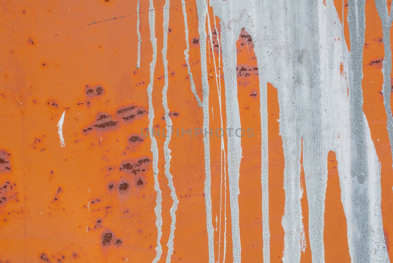 fragment of an iron surface is covered with orange color paint, which has long been under the influence of different climatic conditions