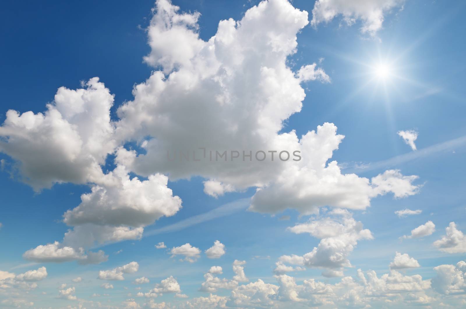 sun on blue sky with white clouds