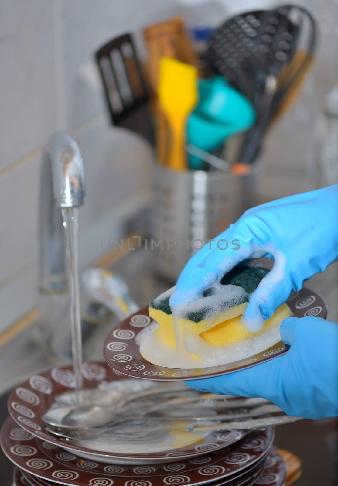 Woman hand washing dishes in the kitchen