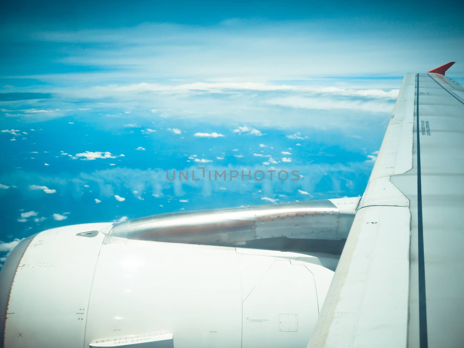 view of jet plane wing with cloud and blue sky by worrayuth