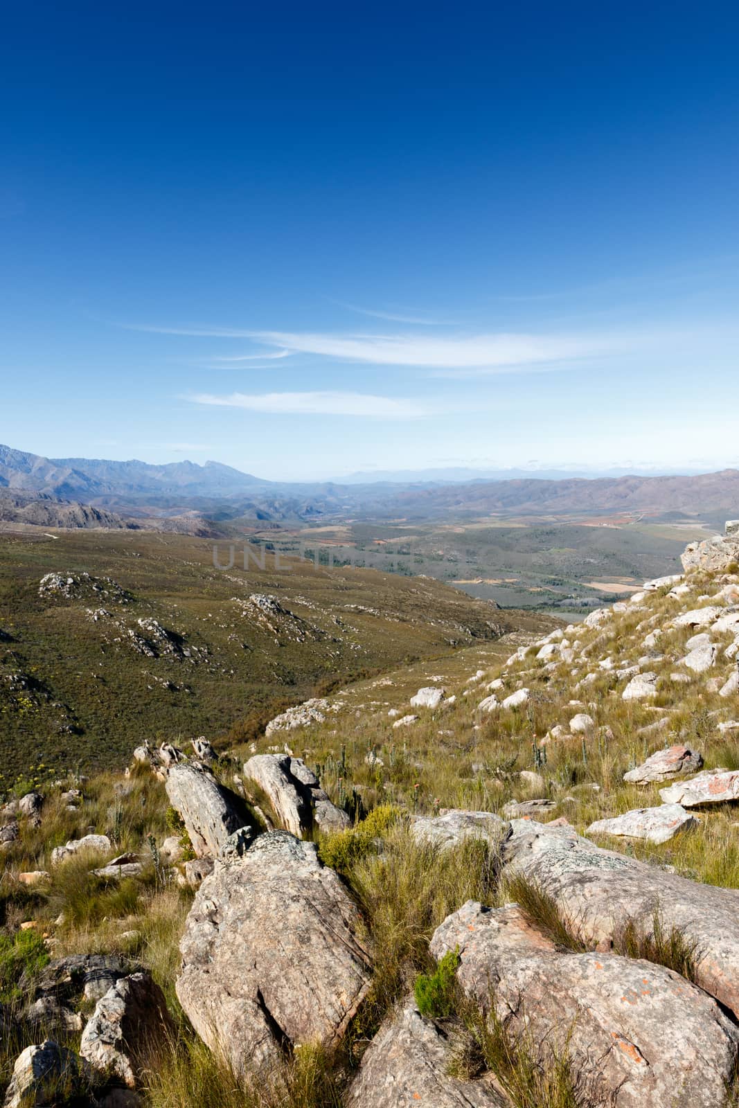 Leading rocks to a valley in the Swartberg mountains with some clouds.