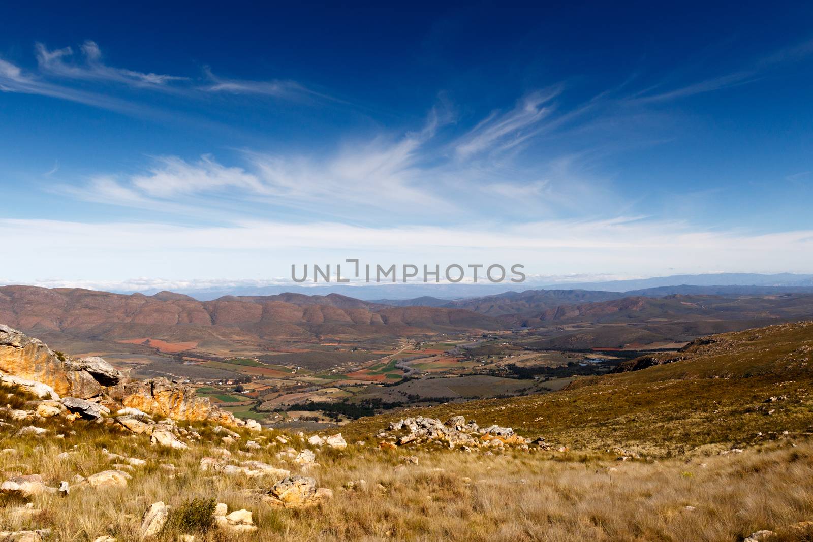 Farmland on a plato with mountains in the background looking over the beautiful Swartberg with clouds.