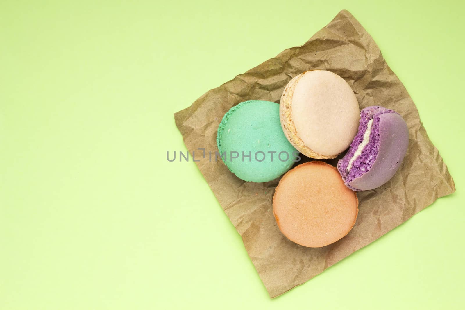 Creative photo of macaroons on green background.