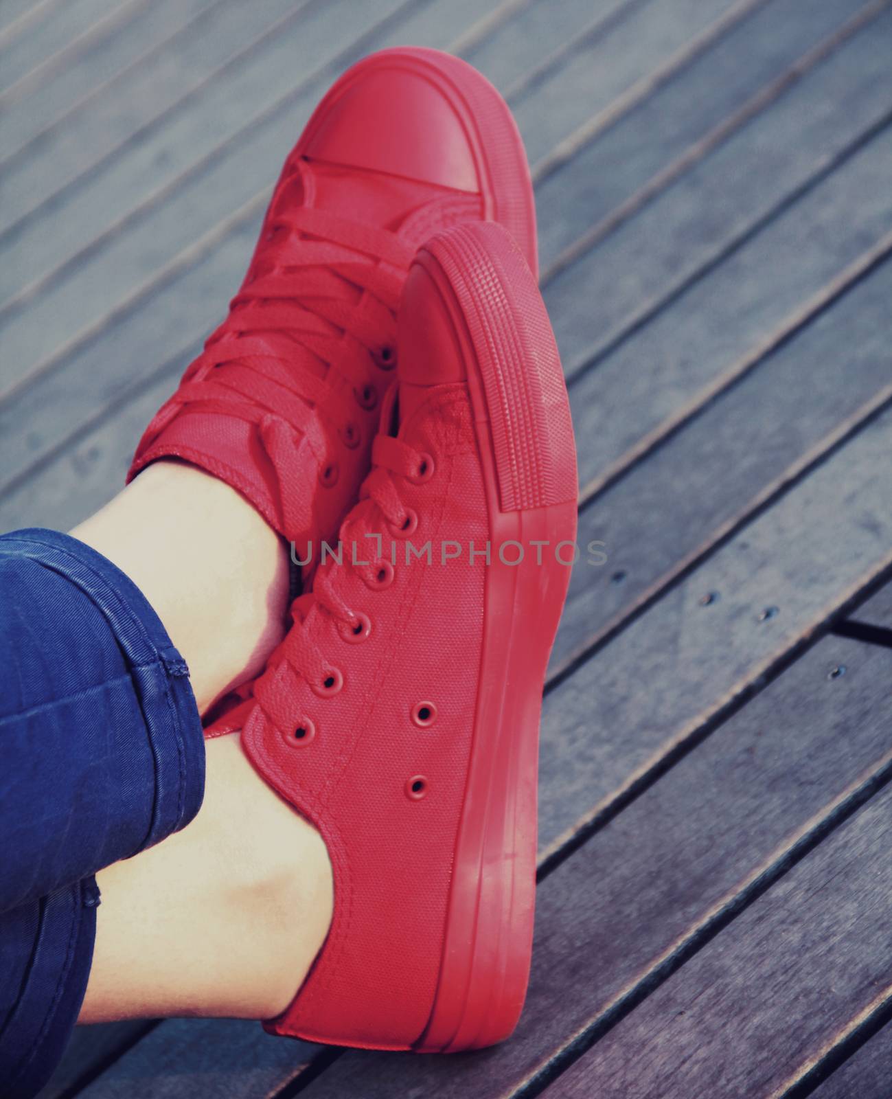  Red sneakers on wooden surface in vintage style