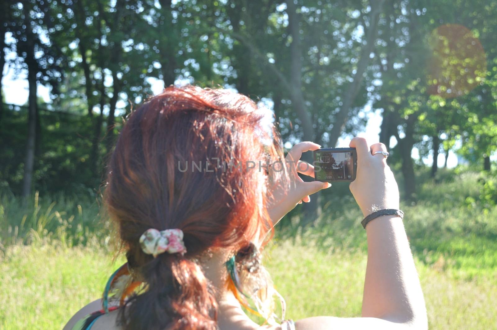 A red  hair woman taking picture  in a park