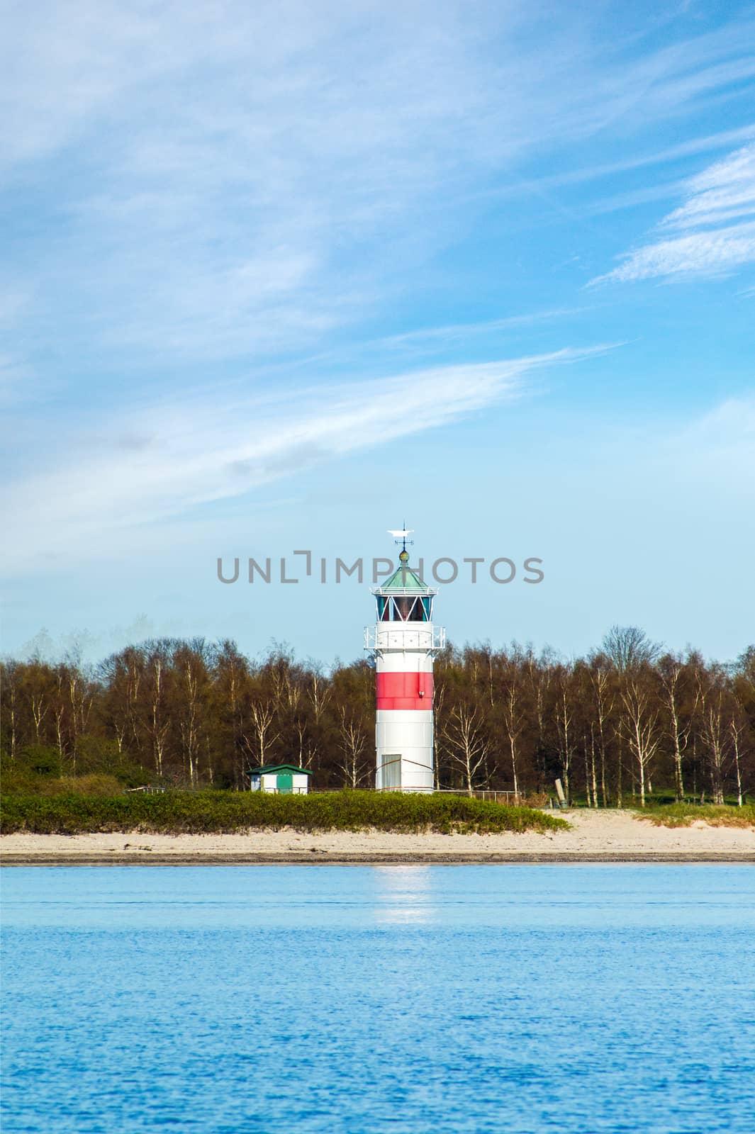Lighthouse at a blue lake by Sportactive