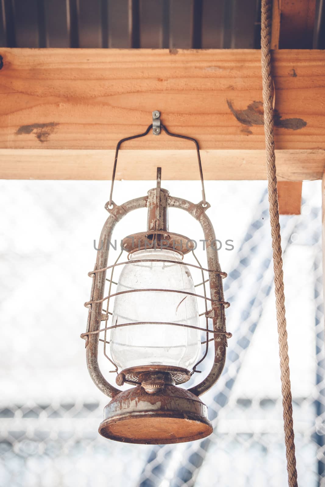 Vintage western lantern hanging on a wooden plank in a barn